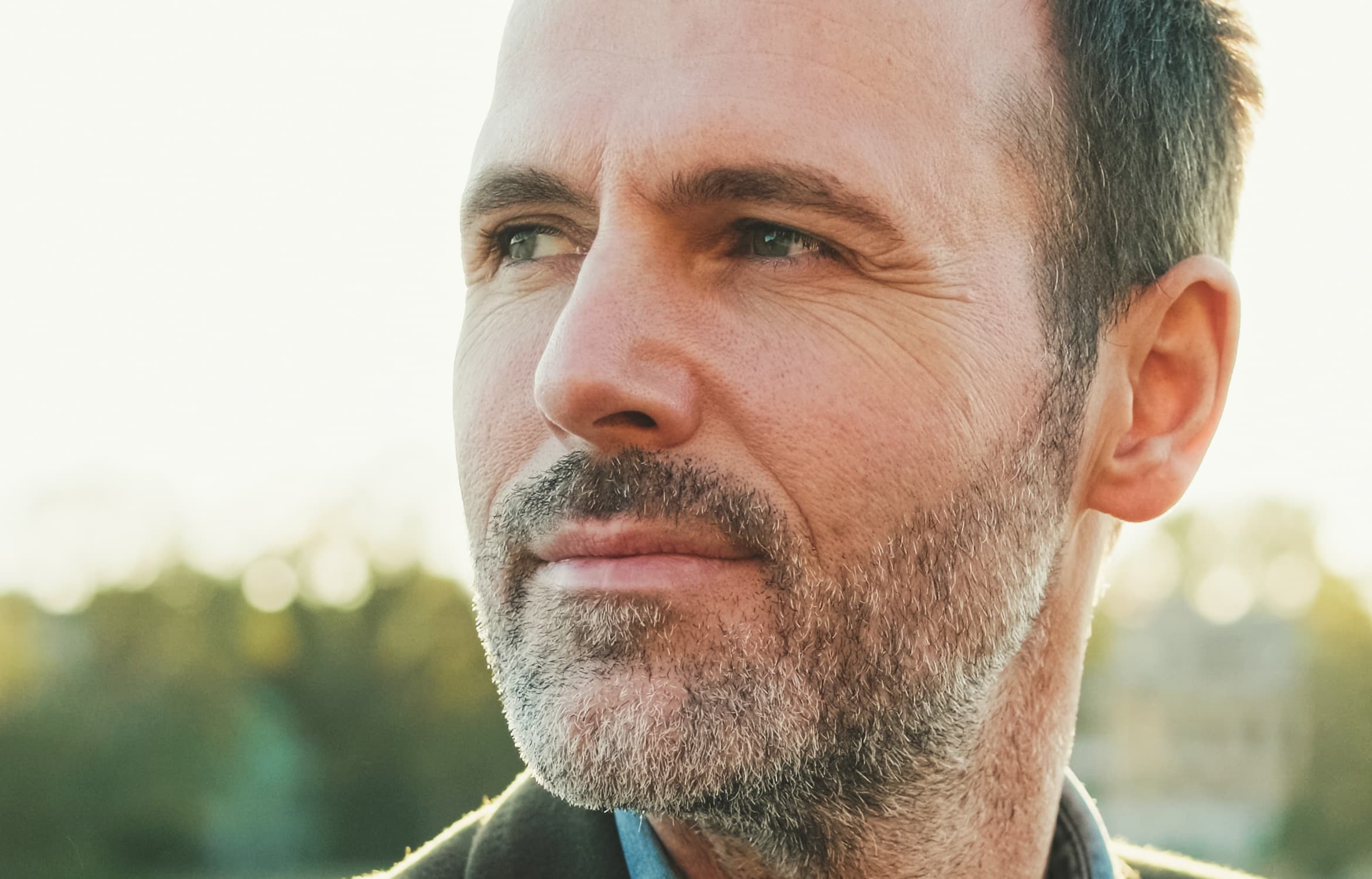 Male Facelift and Neck Lift: A smiling middle-aged man with smooth skin and youthful facial contours